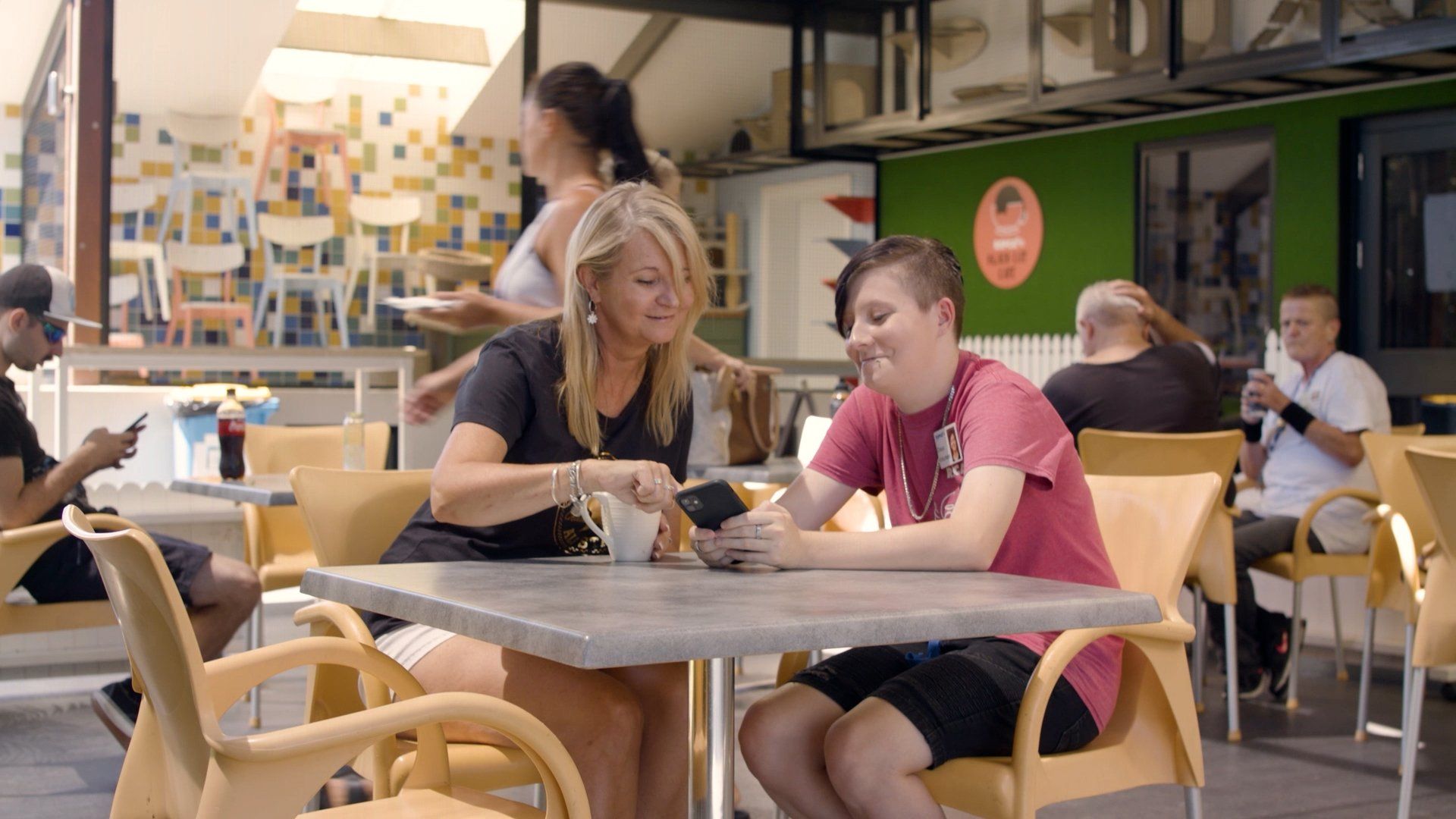 Mum+and+participant+at+the+cafe+looking+at+their+phone.jpg
